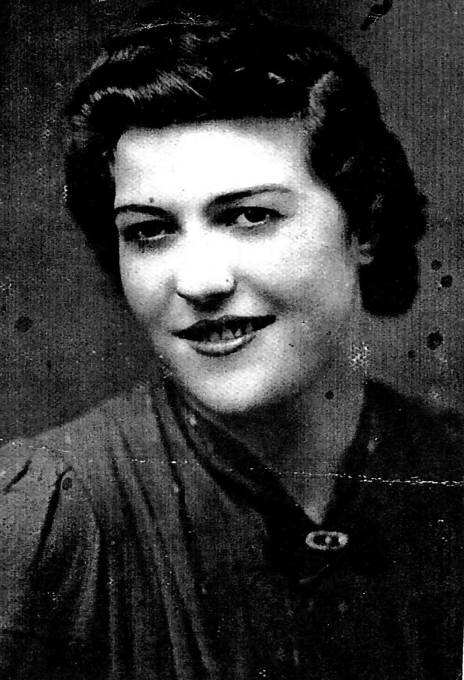 black and white family photograph of a woman with black hair and dark eyes smiling at the camera